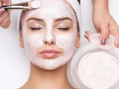 Young beautiful woman receiving  facial mask in spa beauty salon
