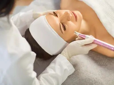 Dermatologist doctor doing cosmetology derma pen beautician procedure, mechanical female face skin cleaning, beauty care tool, dermatoscope instrument, micro-needling clinic boosts natural collagen